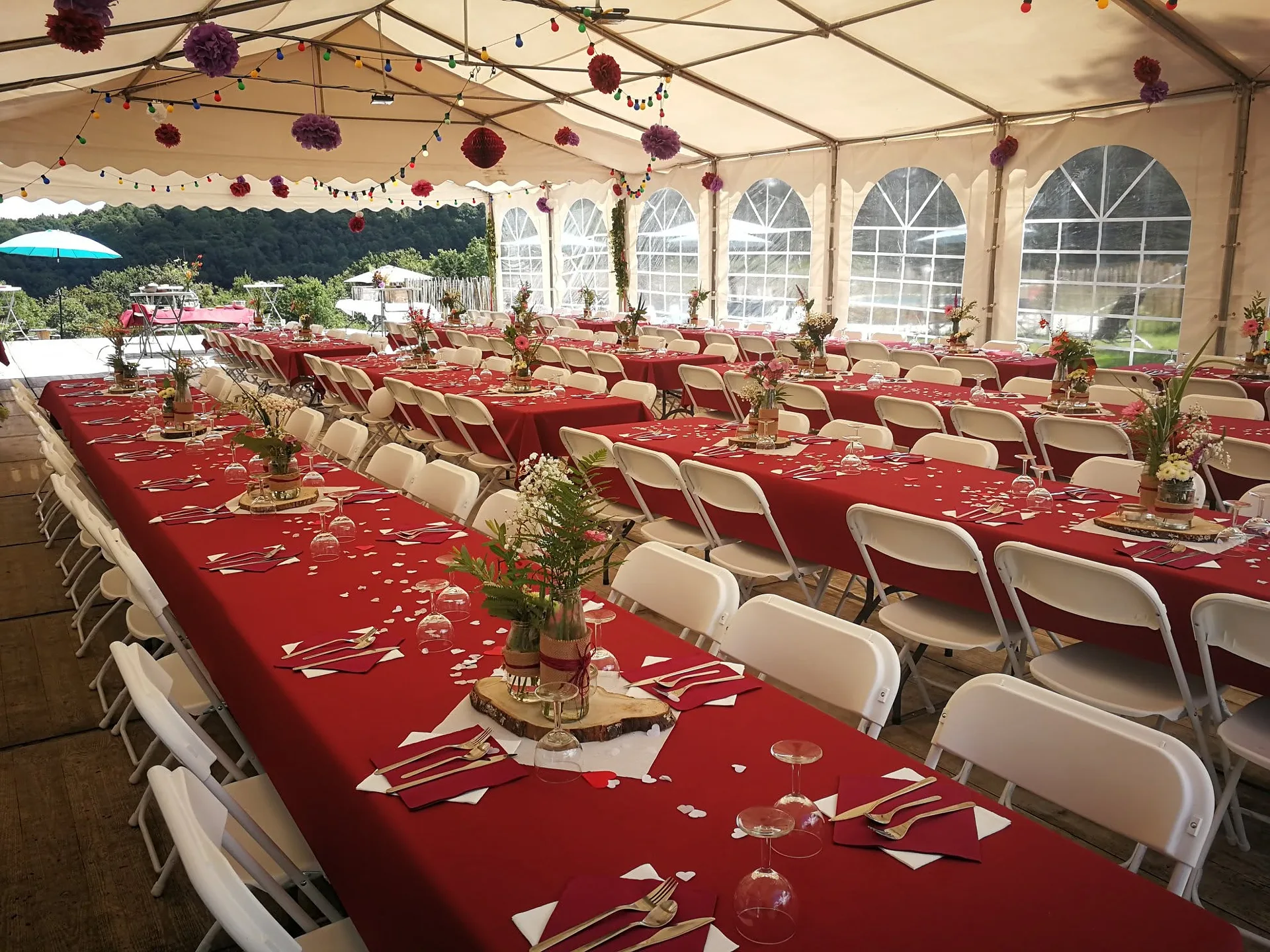 Banquet aux nappes rouges dressé sous le chapiteau