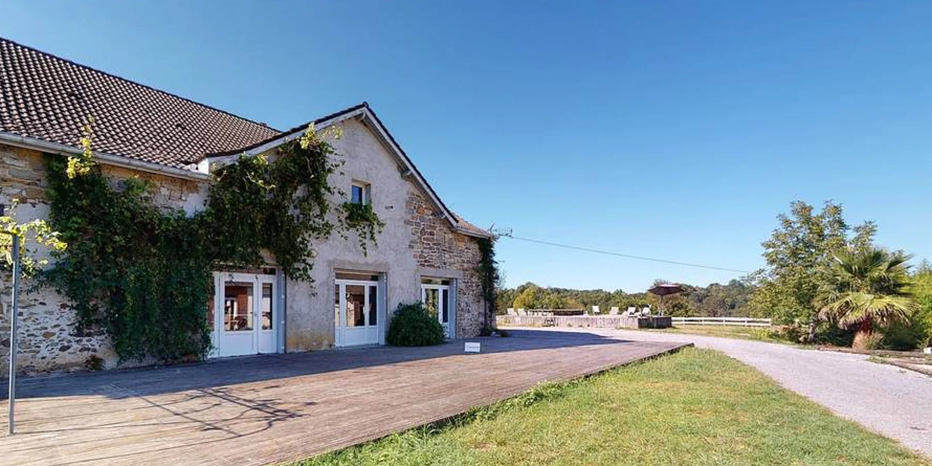 Le bâtiment en pierre du domaine, sa vigne et son allée d'accès