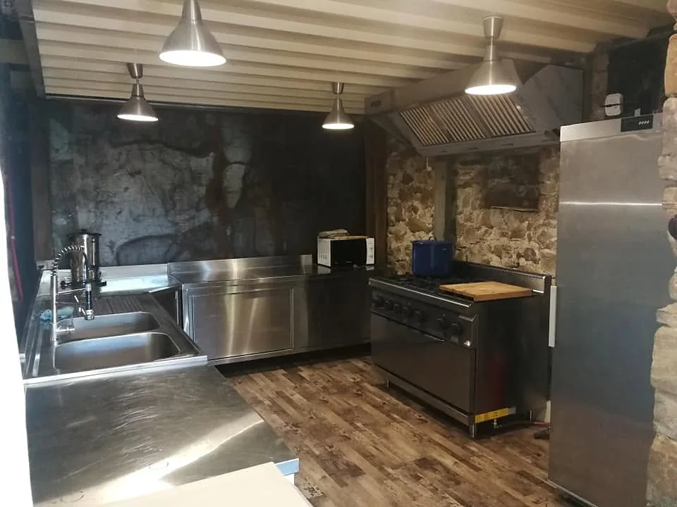 Plans de travail en inox sous les murs en pierre
