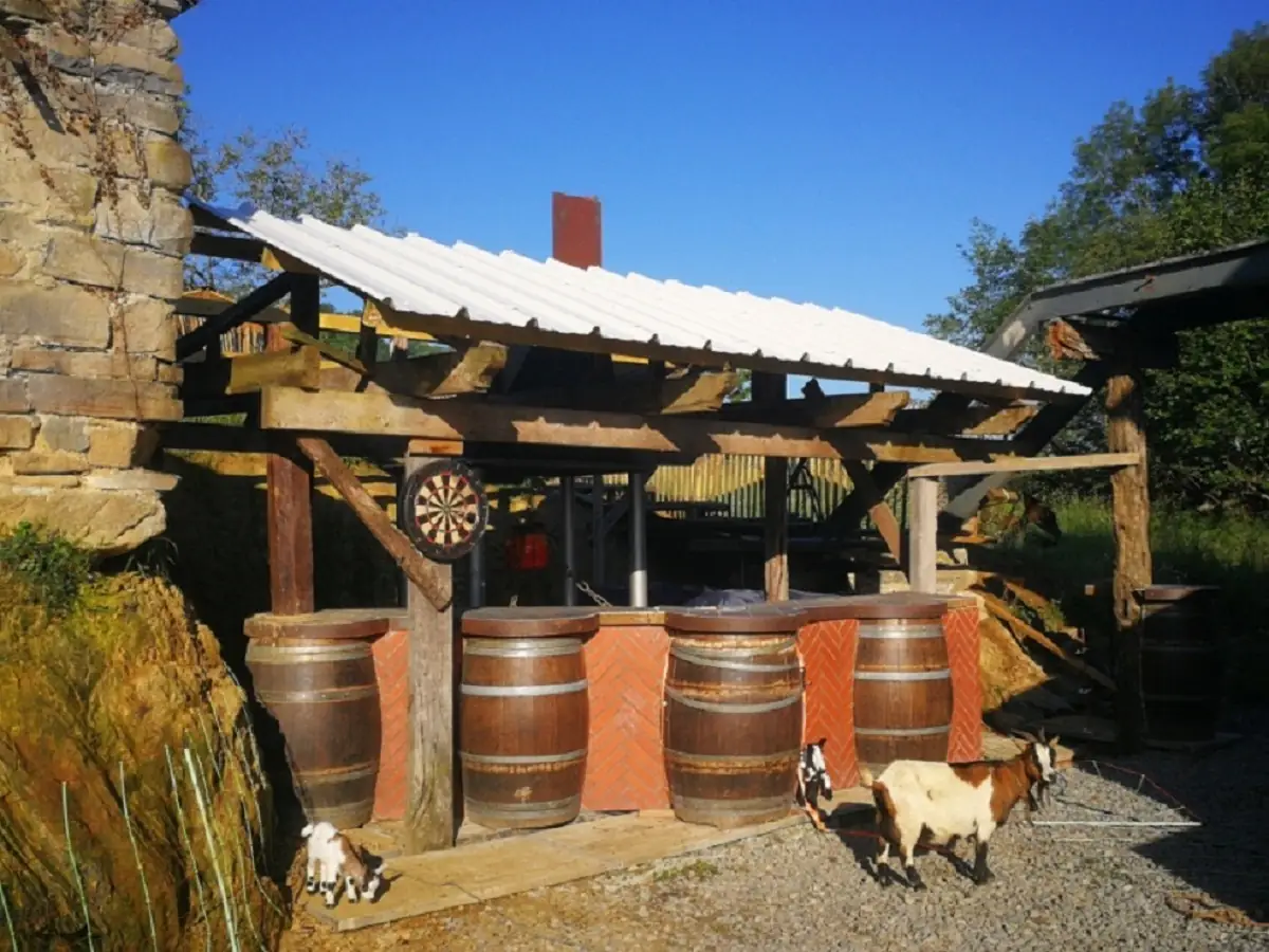 Espace en bois avec tonneaux sous une pergola