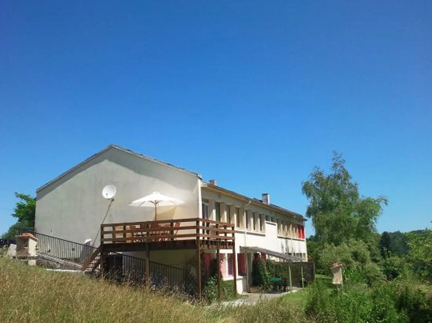 Le bâtiment blanc du gîte et son balcon, avant les travaux