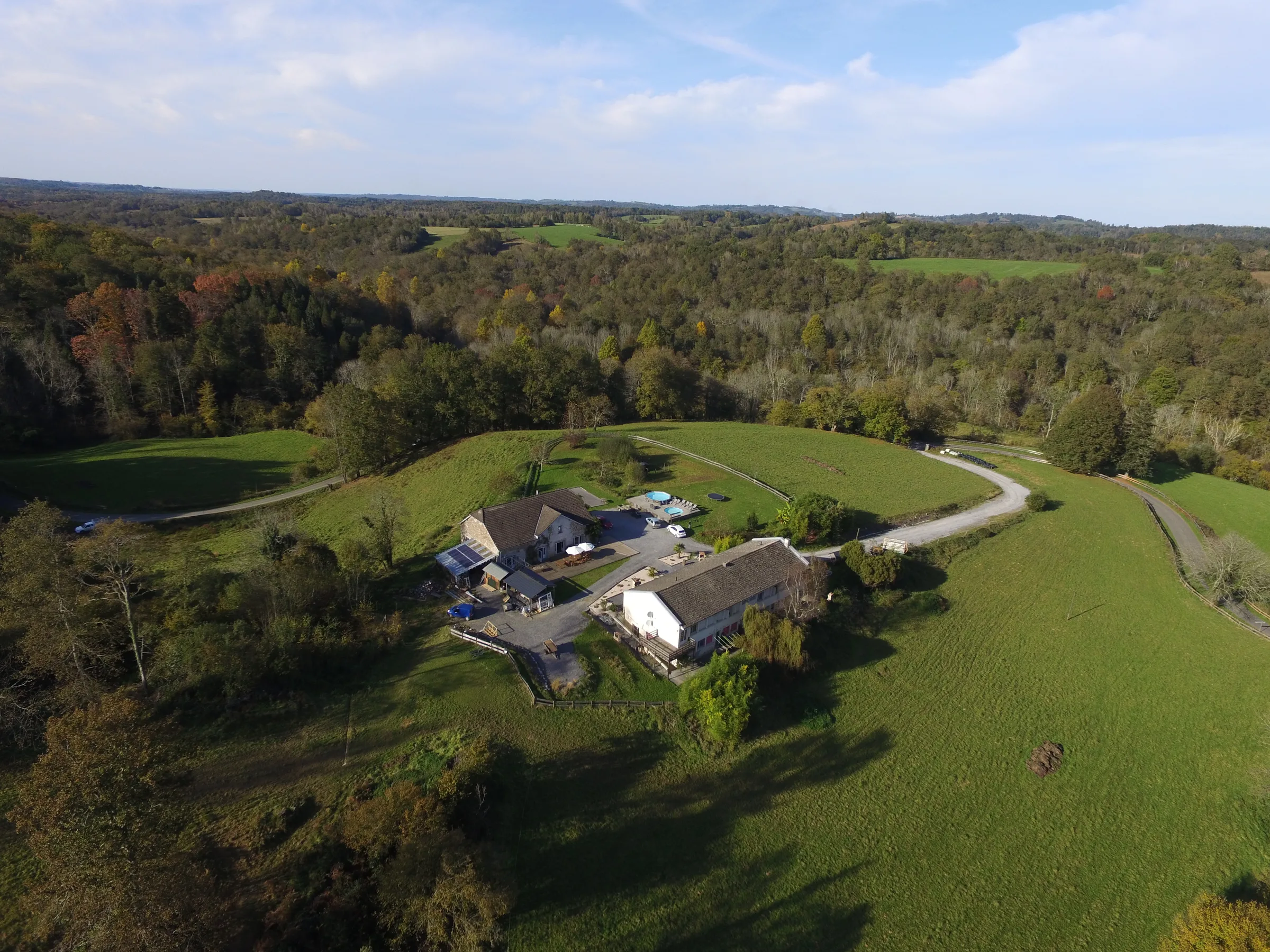 Vue aérienne du gîte Passiflorart, ses deux bâtiments et ses piscines dans la vallée d'Ossau
