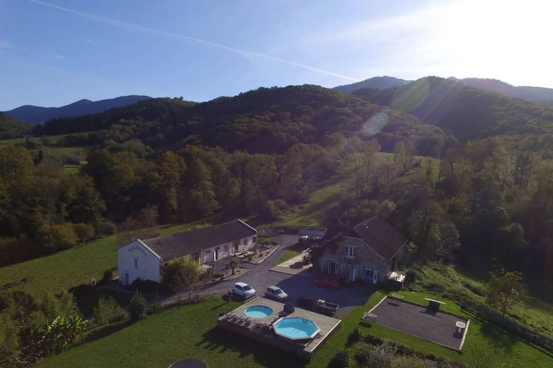 Le gîte, ses piscines et la montagne au couchant