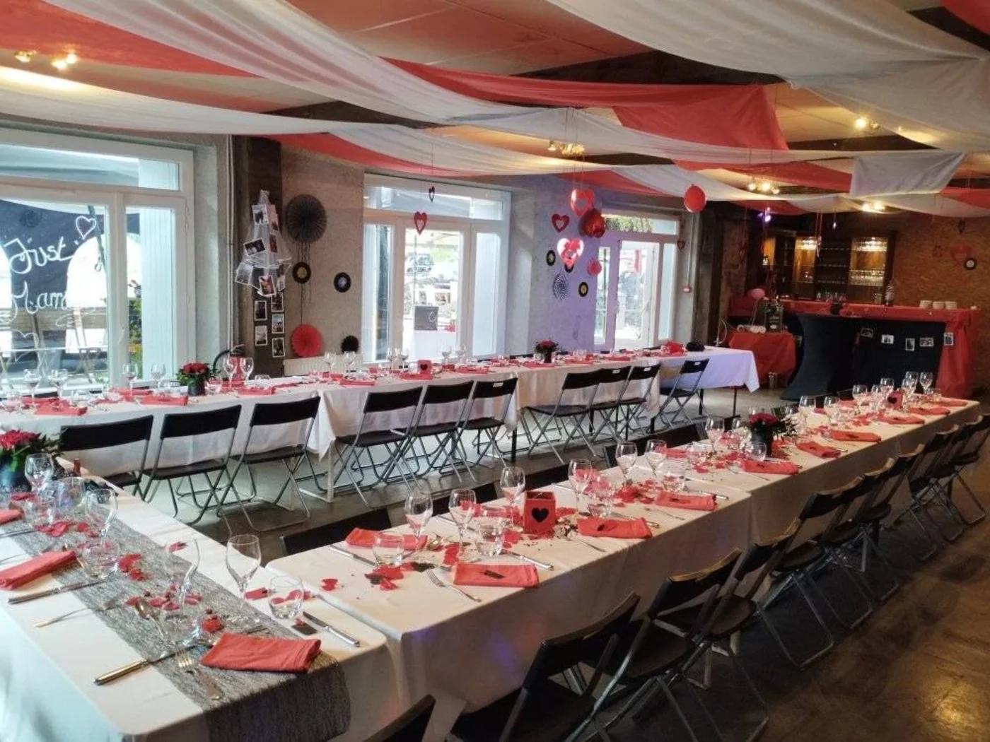 La grande salle du gîte, ses tablées dressées en rouge et blanc et son plafond tendu