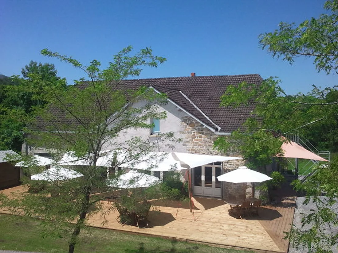 La terrasse en bois et ses voiles d'ombrage, côté salle