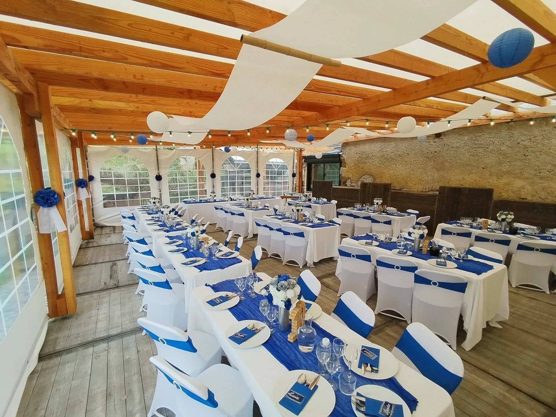 Chaises housssées et chemins de table bleus