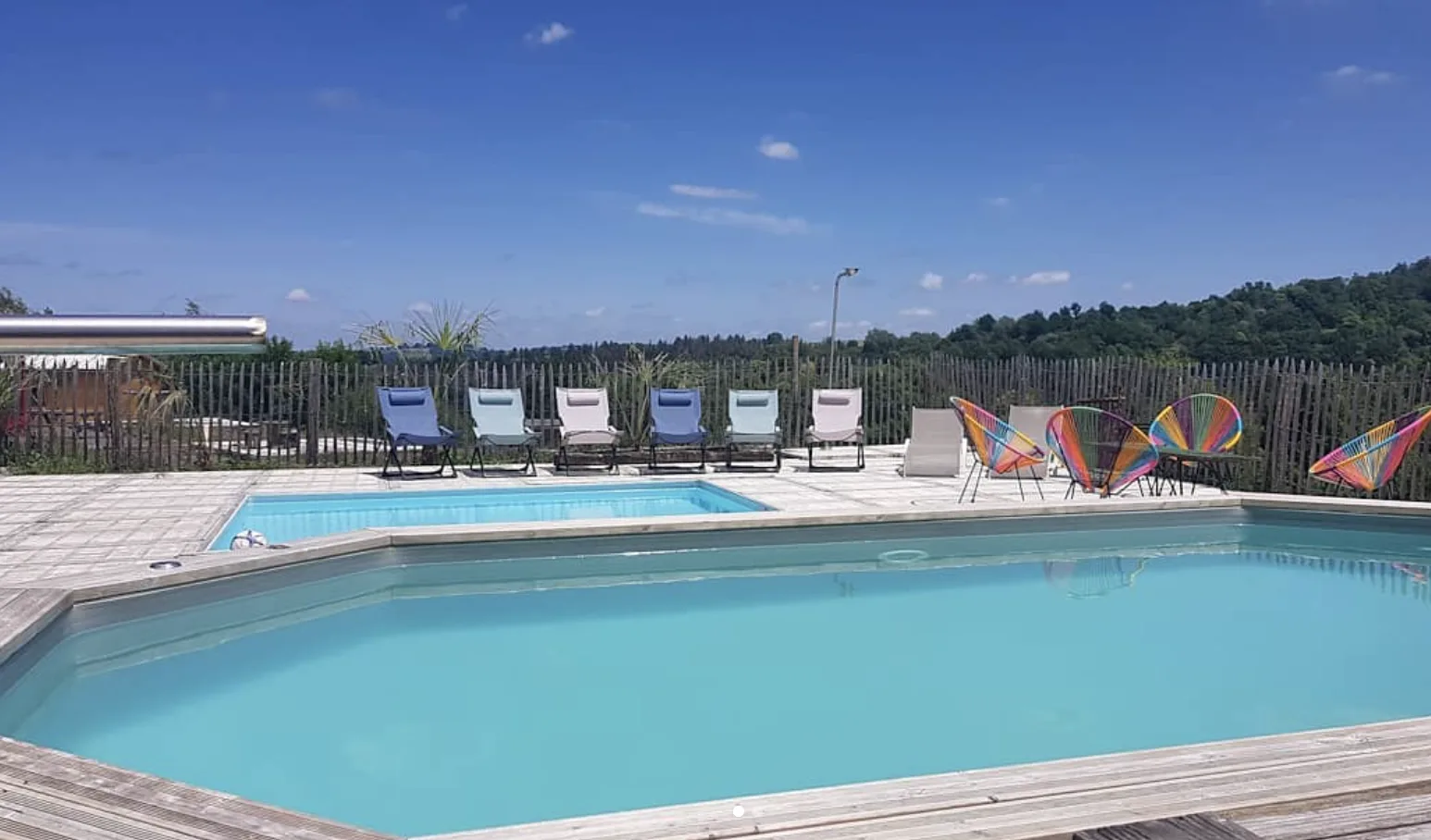 Les deux piscines du domaine, leurs transats et leurs fauteuils colorés