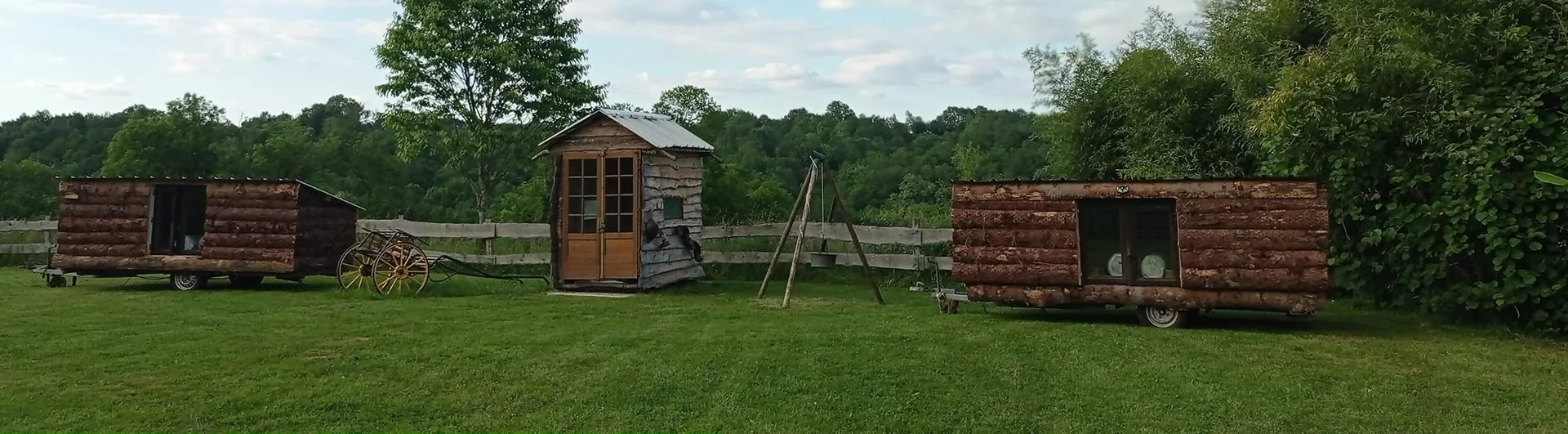 Les roulottes en rondins et le petit chalet, posés dans la prairie