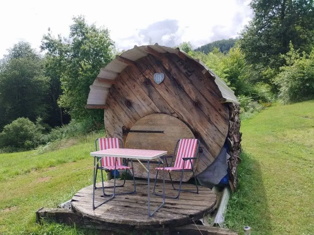 Tonneau en bois aménagé avec sa terrasse, hébergement insolite du domaine
